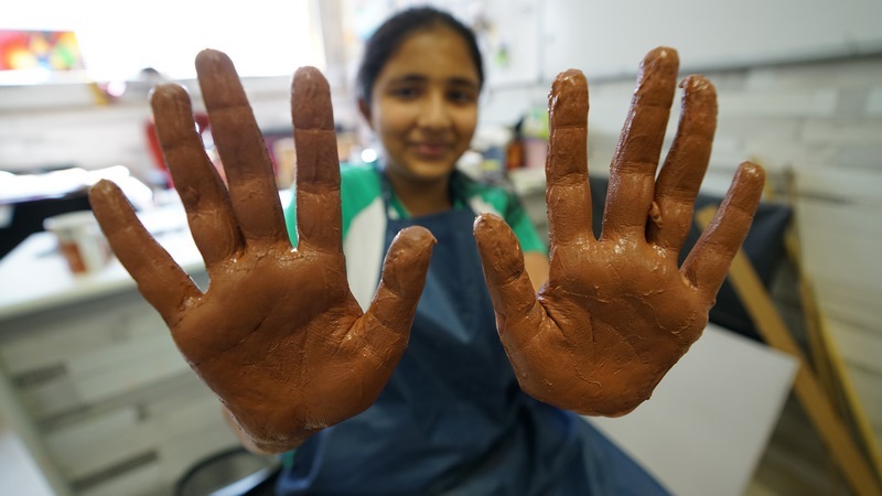 Girl happily showing her muddy hands